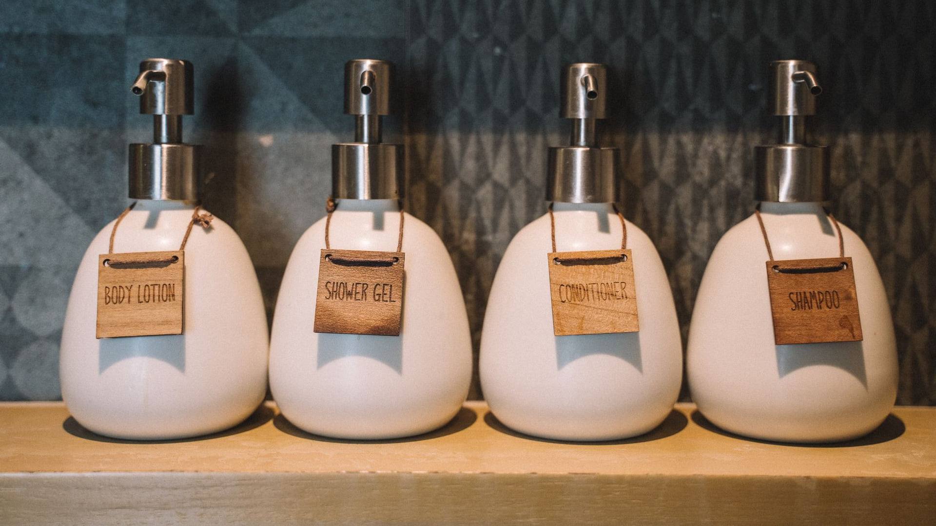 Flacons de shampoing, gels douche et savons disposés de manière ordonnée dans un rayon de supermarché