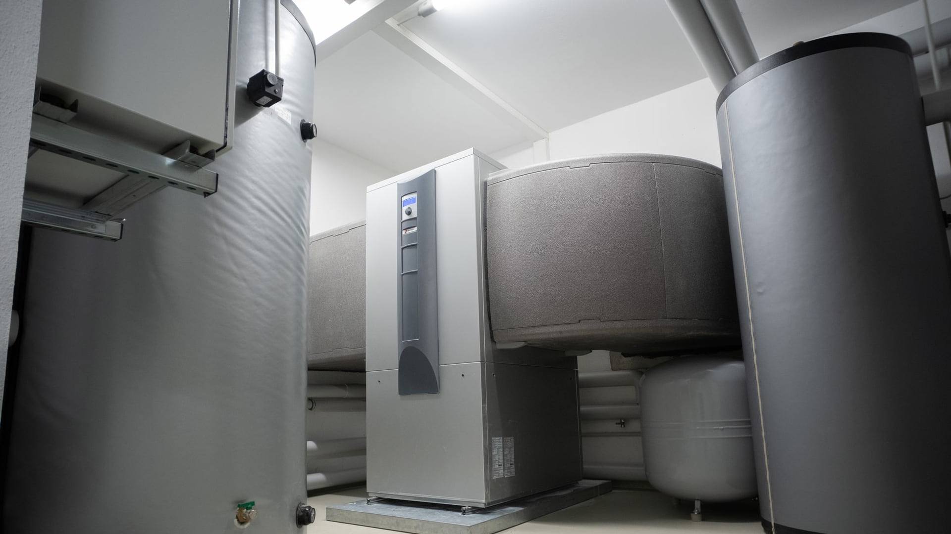 Un compteur d'énergie domestique à côté d'un boîtier de régulation de chauffage central dans un logement moderne.