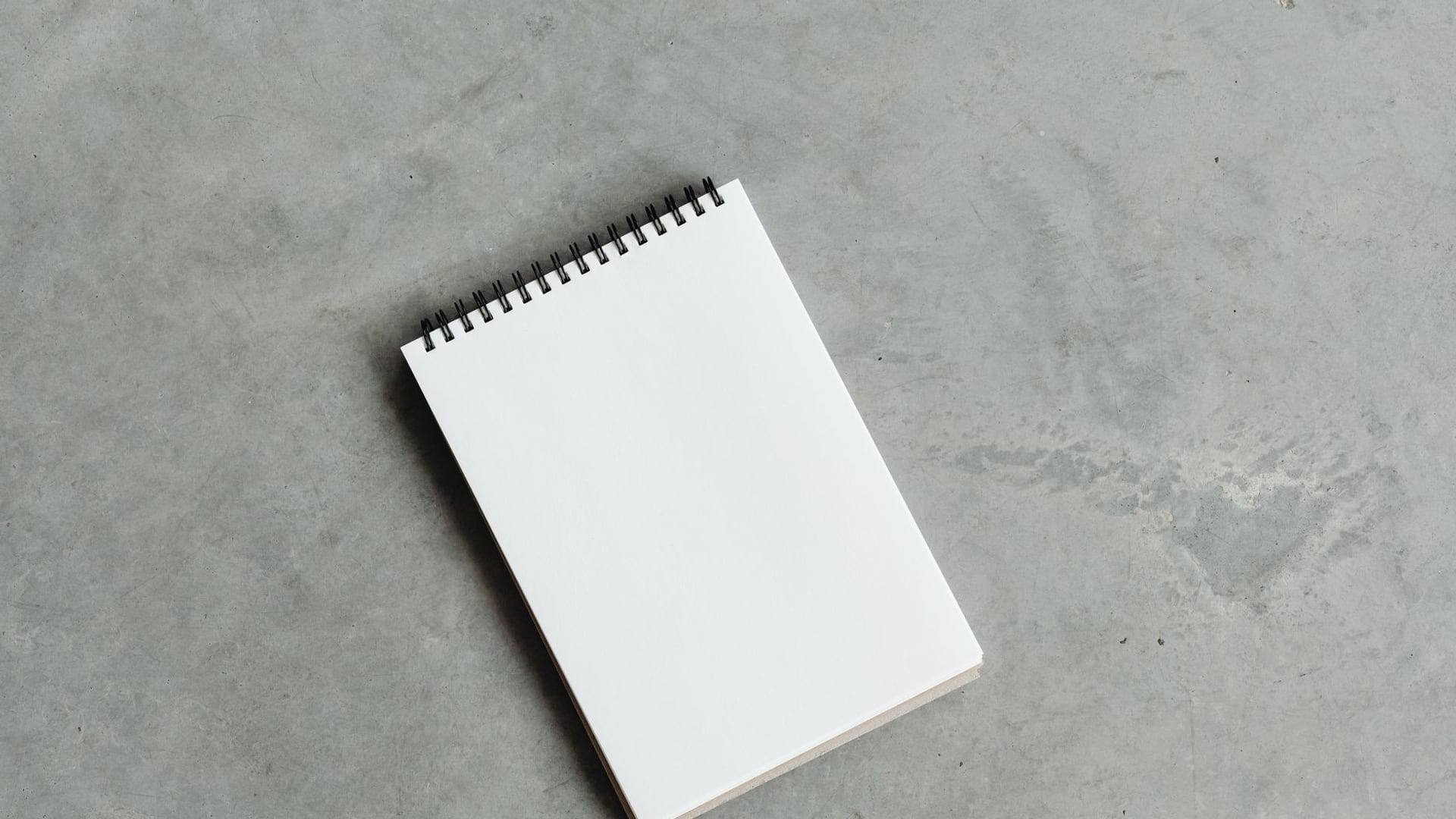 Un compteur de gaz naturel fixé sur un mur extérieur à côté d'un carnet de notes et d'une calculatrice posés sur une table