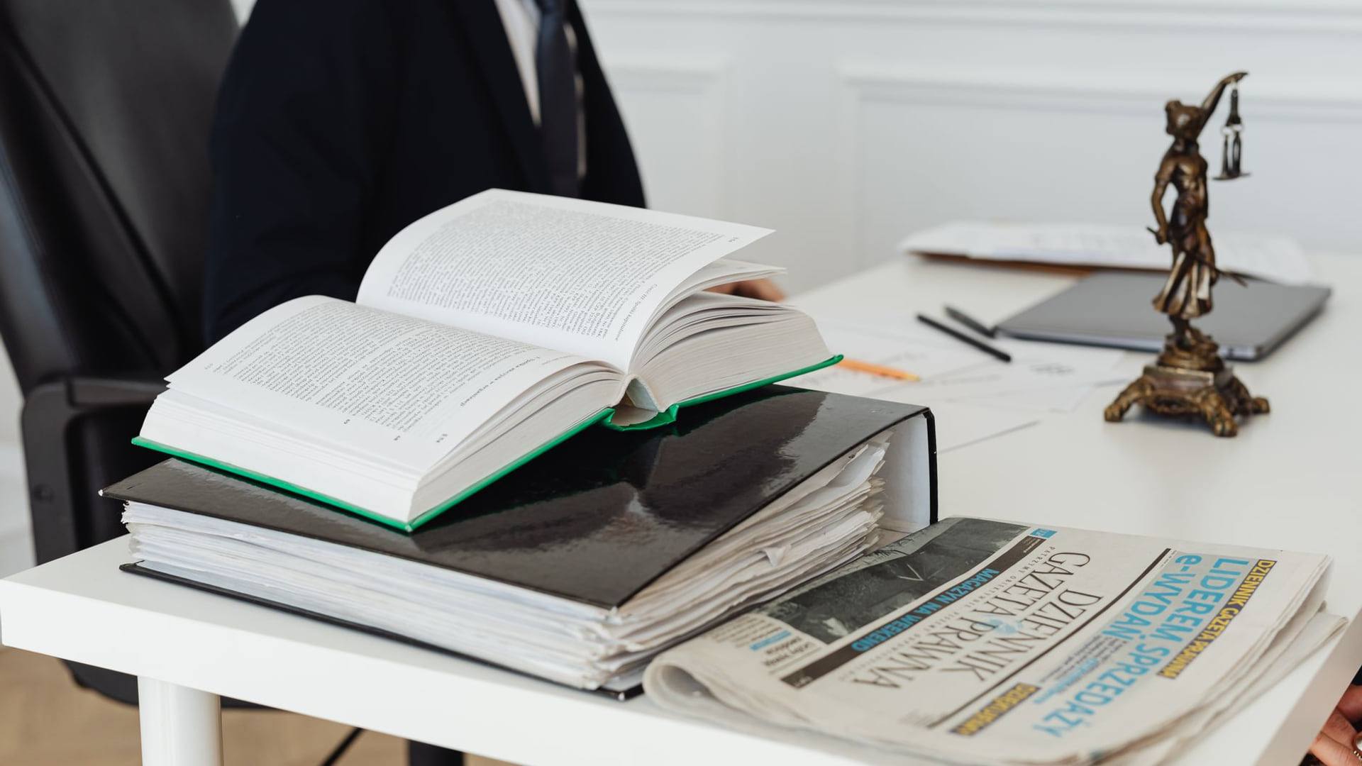 Un dossier juridique ouvert sur un bureau avec un marteau de justice en bois et des documents d'un litige commercial