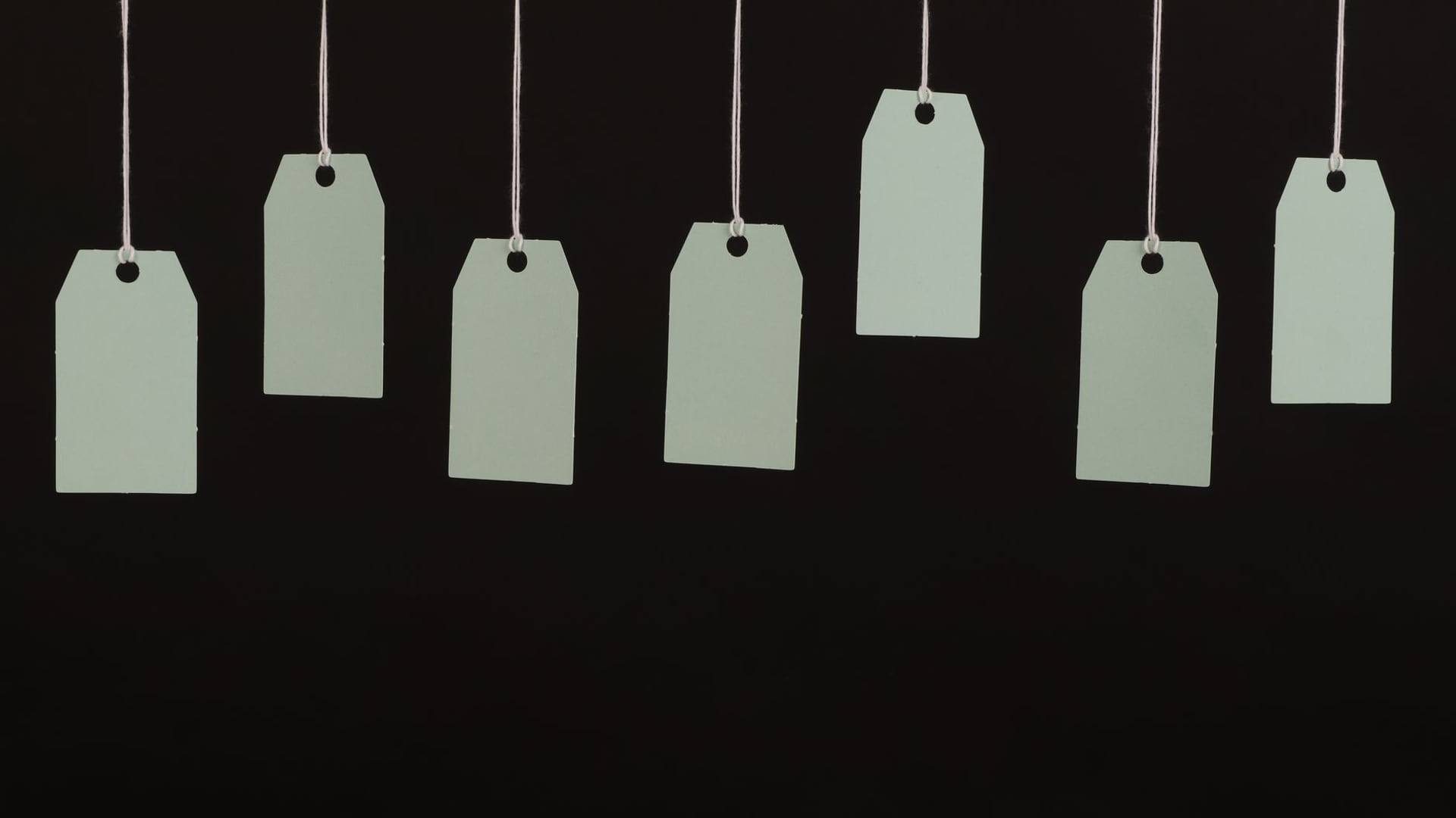Une personne examinant l étiquette de prix d un vêtement suspendu dans un magasin de vêtements