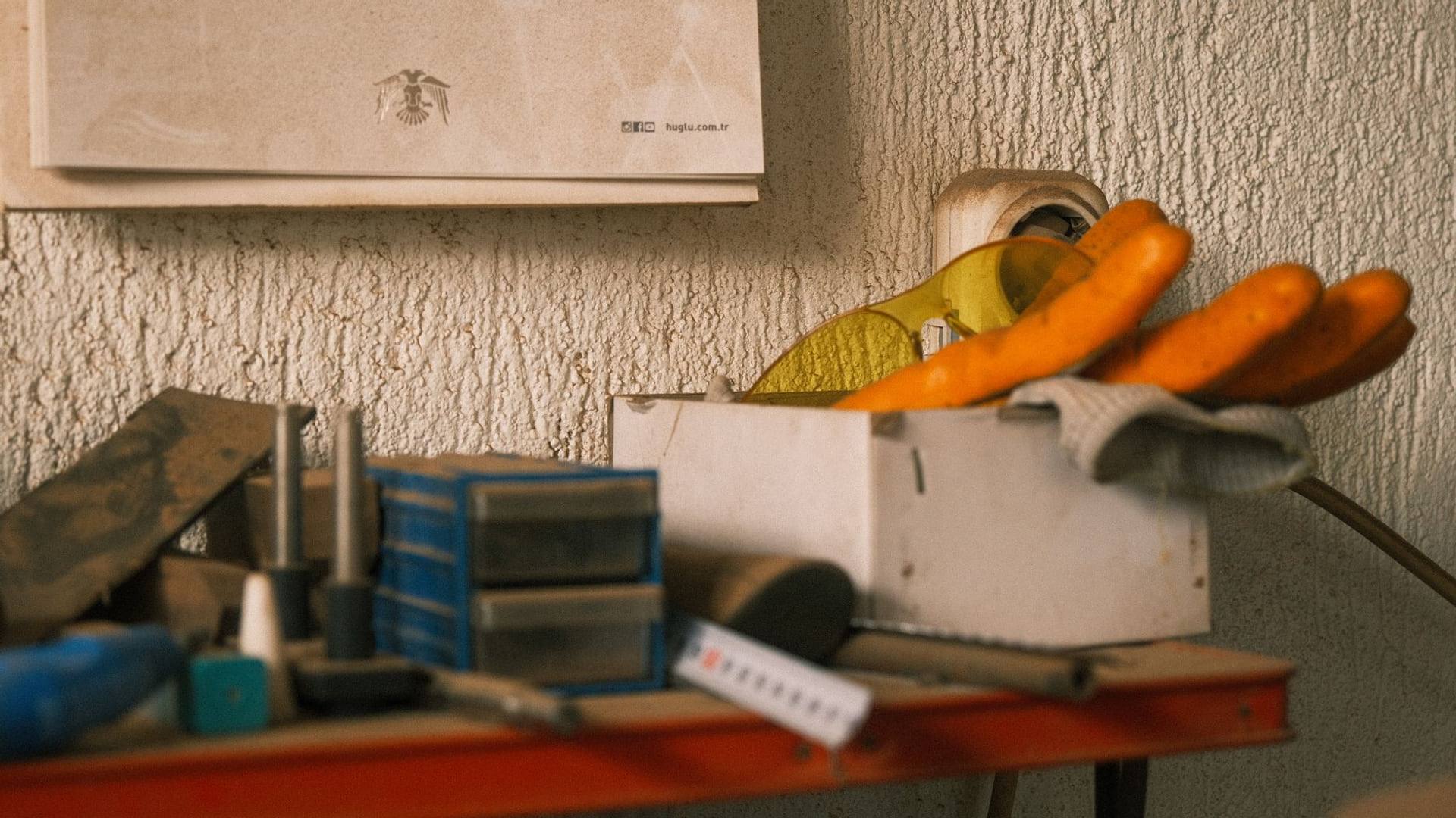 Un atelier ordonné avec des outils électroportatifs posés sur un établi en bois à côté d'une tablette tactile affichant un calendrier.