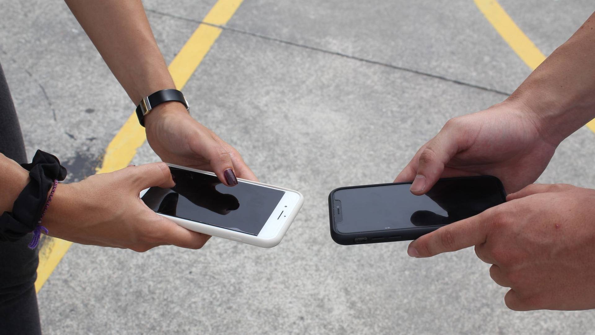 Un comparatif minutieux entre deux smartphones reconditionnés posés sur une table de travail en bois