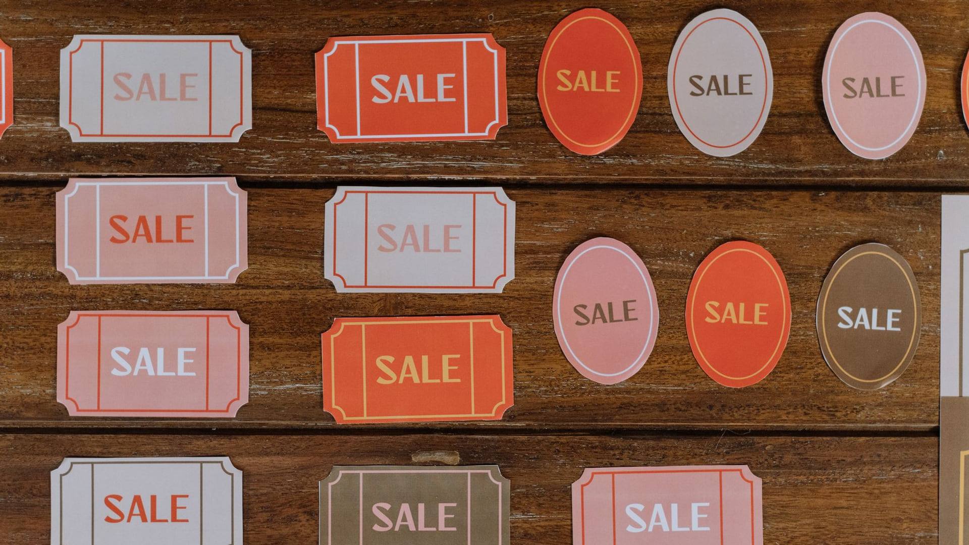 Une personne consulte une étiquette de prix avec réduction affichée sur un meuble en bois dans un magasin de mobilier.