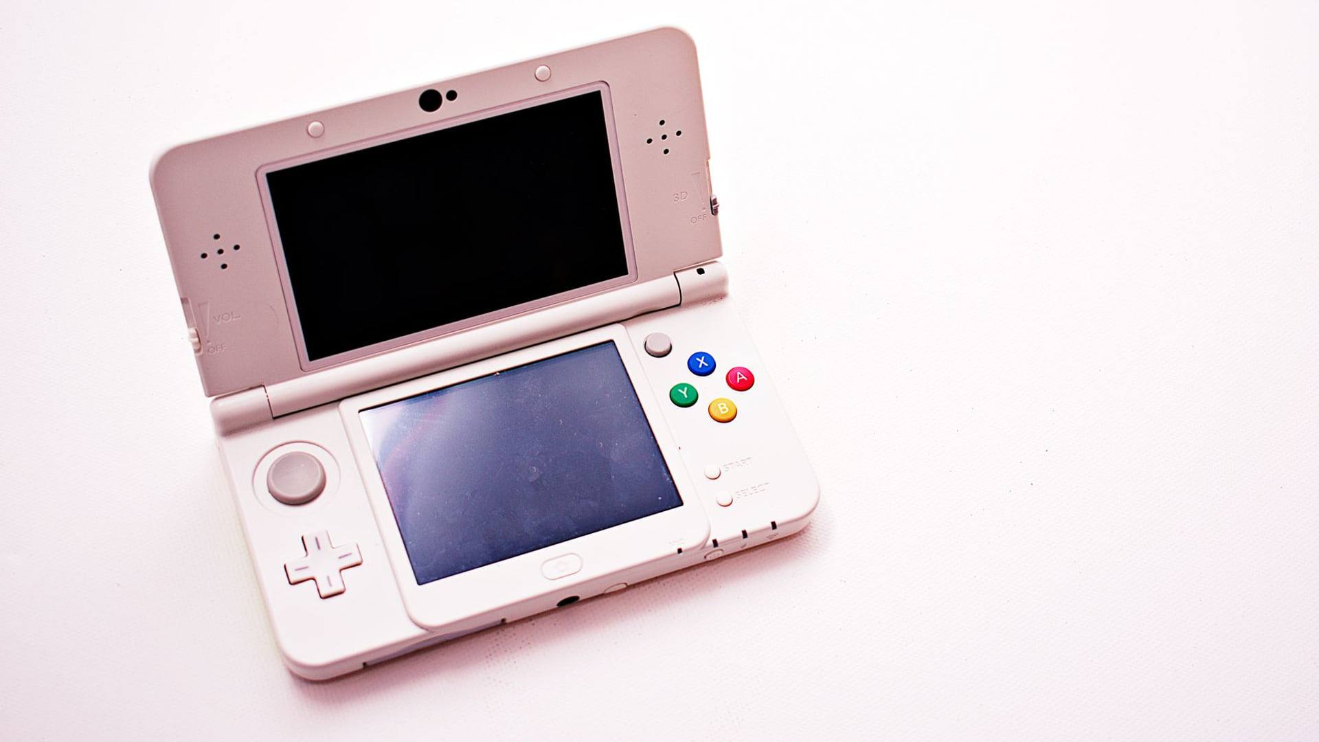 Un pack comprenant une console de jeu vidéo moderne entourée de manettes et de boîtes de jeux posés sur une table en bois.