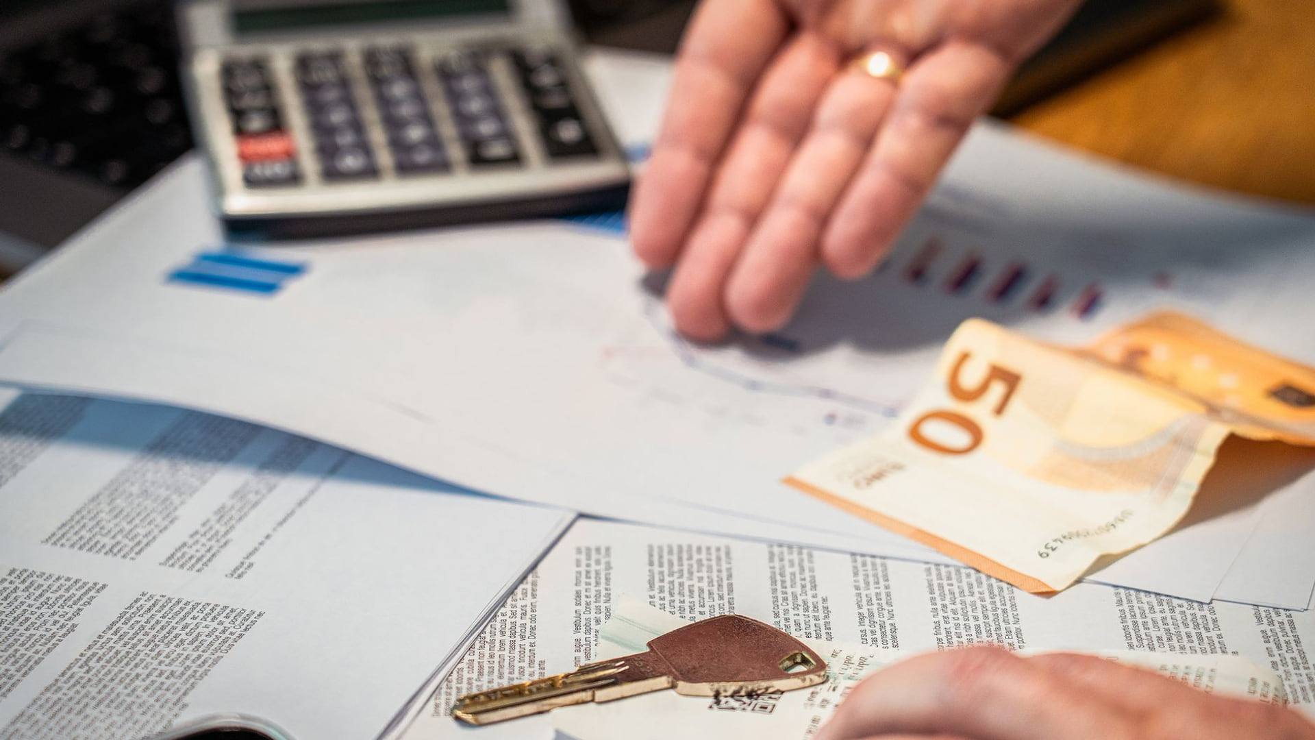 Une personne analyse un contrat de paiement échelonné sur un smartphone posé sur un bureau.