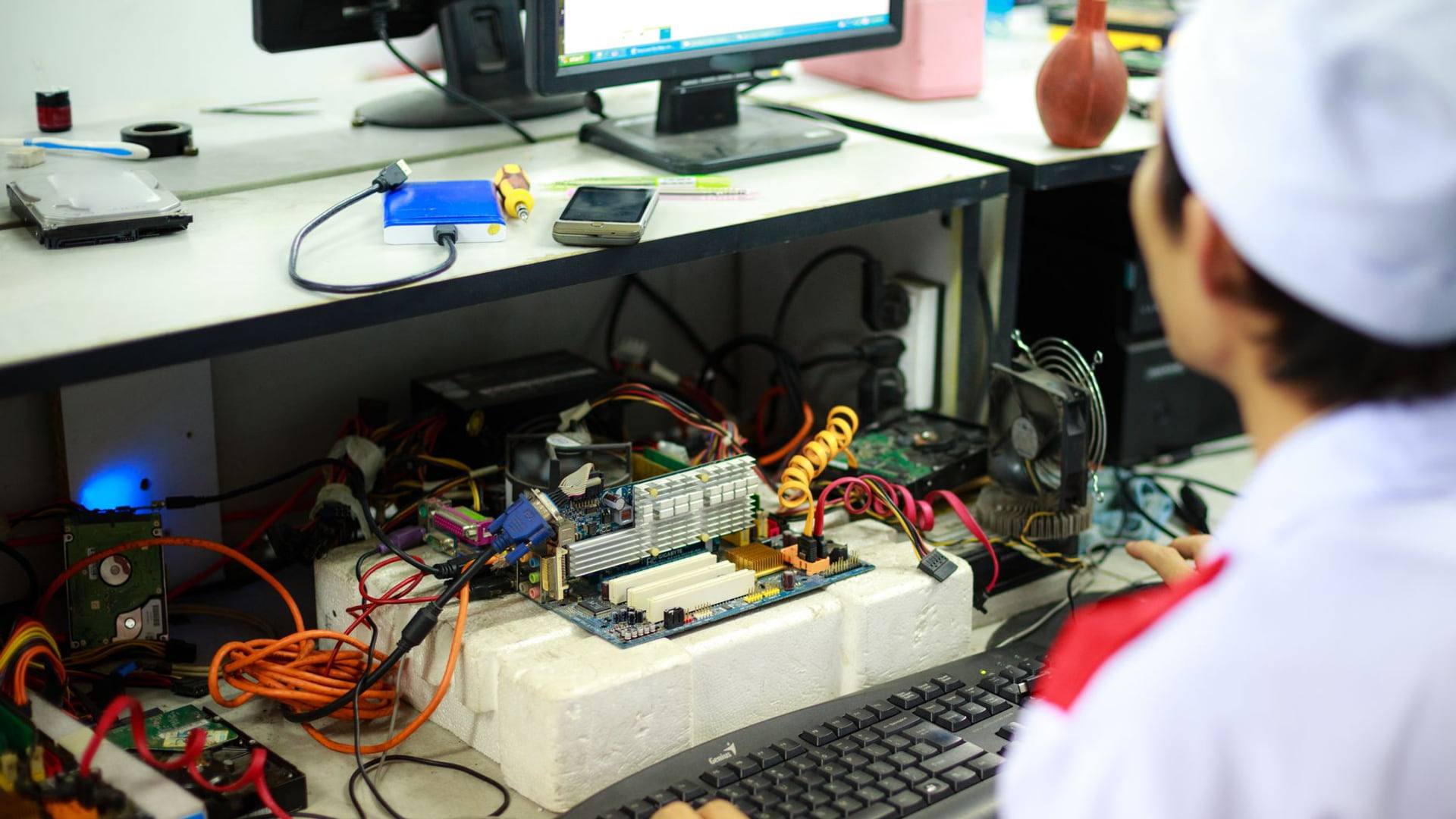 Un technicien minutieux posant un composant électronique d'ordinateur portable sur un tapis de travail antistatique.