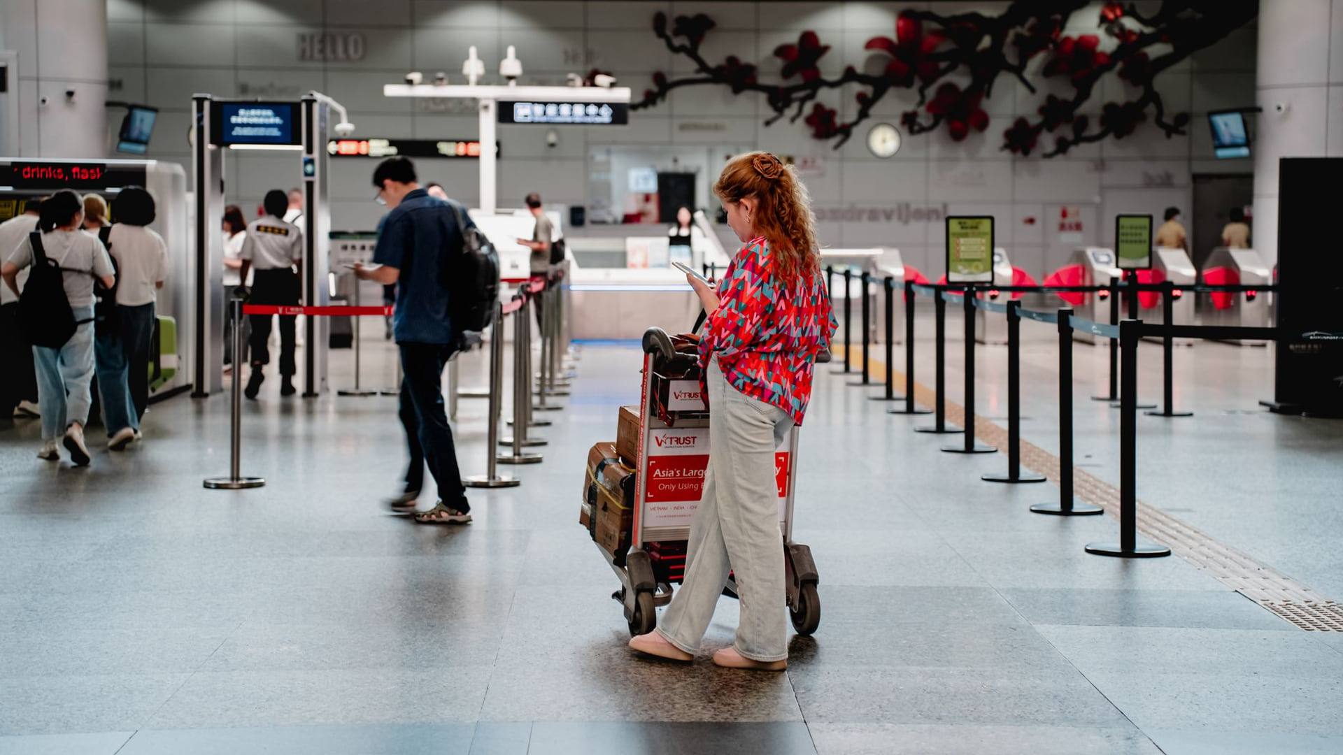 Passagers patientant dans le hall d'un aéroport moderne près des comptoirs d'embarquement avec leurs valises